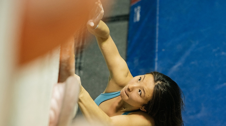 a young woman climbing a wall in a gym