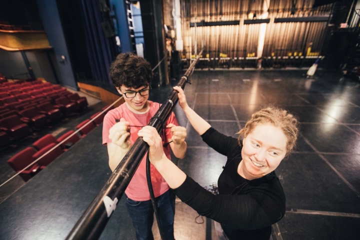 two students setting up a prop on stage