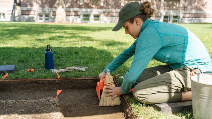 Katie Hoover ’22 helps with an archeological excavation of a mansion buried under the lawn in front of Dartmouth Library’s Baker-Berry Library.