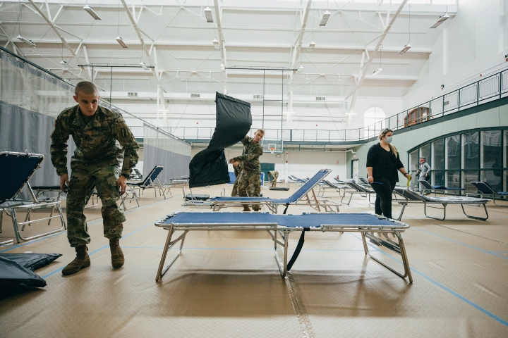 Soldiers set up cots in Alumni Gym