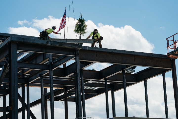 Workers install the highest steel beam atop the new Center for Engineering and Computer Science.