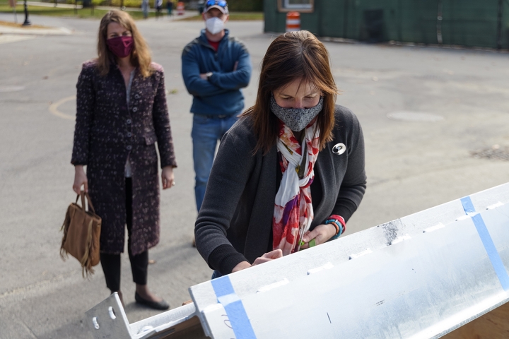 Professor of Environmental Sciences Elizabeth Wilson, the institute's founding director, signs the final beam.