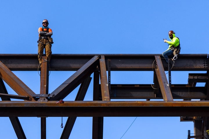 Construction workers await the beam's arrival.