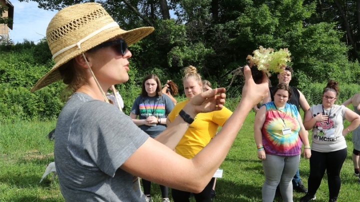 : At the Dartmouth Organic Farm, SEAD scholars—who were on campus for a week in June to experience college life—listen as farm program manager Laura Braasch explains how to plant lettuce.