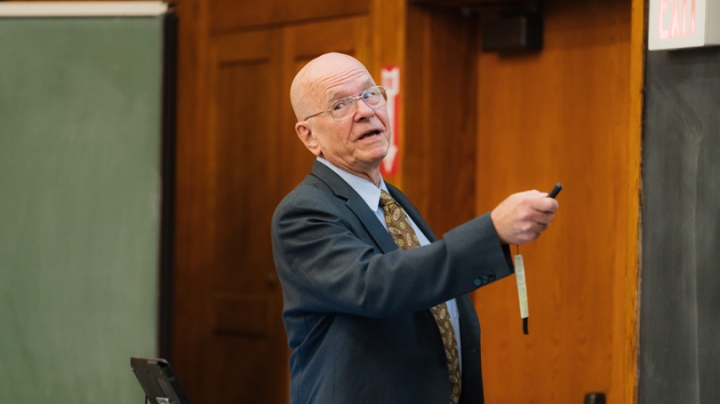 K. Barry Sharpless '63 speaking in a College lecture hall, stsanding in front of a chalkboard