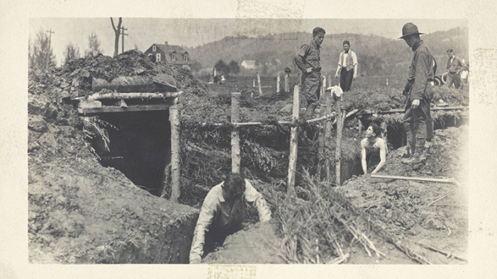 a black and white photo of students digging trenches outside