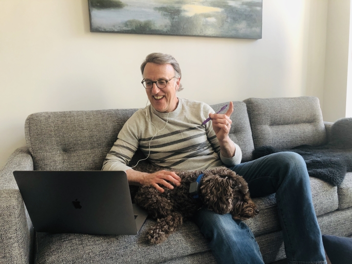 Lee Coffin, and his dog, sit on his couch. 