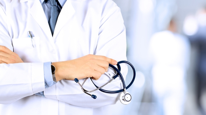 a doctor in a white lab coat holding a stethoscope