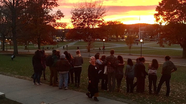 Pati Hernández standing with students and teaching assistants on the Green at sunset