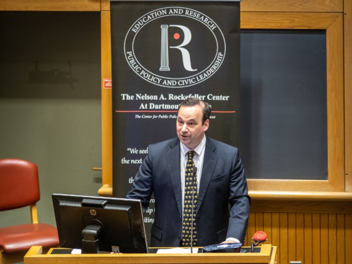 Rockefeller Center Director Andrew Samwick standing at a podium, introducing a public policy discussion at the center