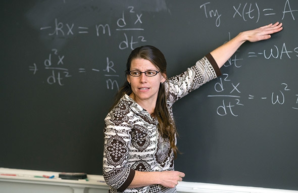 Associate Professor of Physics and Astronomy Robyn Millan pointing at the blackboard