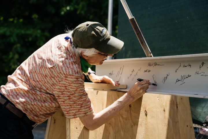 Eric Hansen, an associate professor of engineering at Thayer, signs the beam before it is set into place.