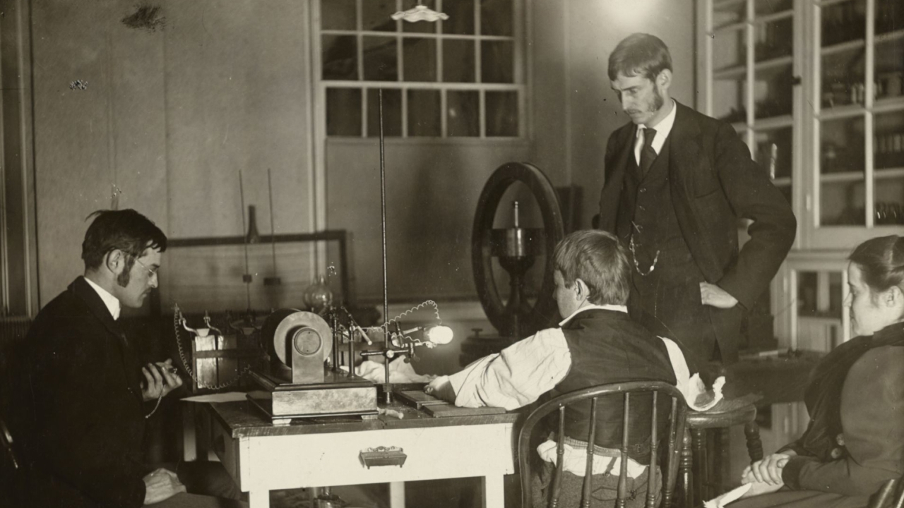 Four people gathered around one of the first xray machines