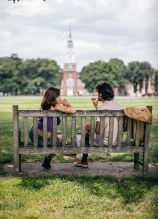 A couple sitting on a bench on the Green.