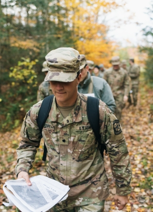ROTC member with a pamphlet in the woods