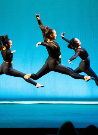 Members of dance troupe Sugar Plum performing against a sky-blue background