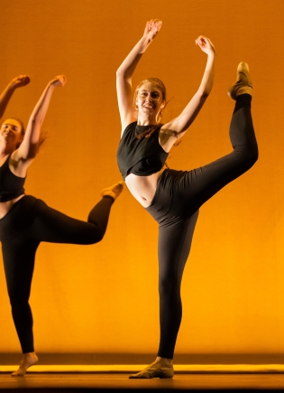 Members of dance troupe Fusion performing against a burnt-orange background