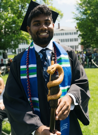 Student holding a serpant carved cane